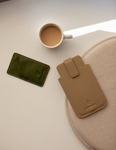 Eine grüne und eine beige Bastei Handyhülle von City Border neben einer Tasse Kaffee, lässig und stylish. Handyhülle Universal.