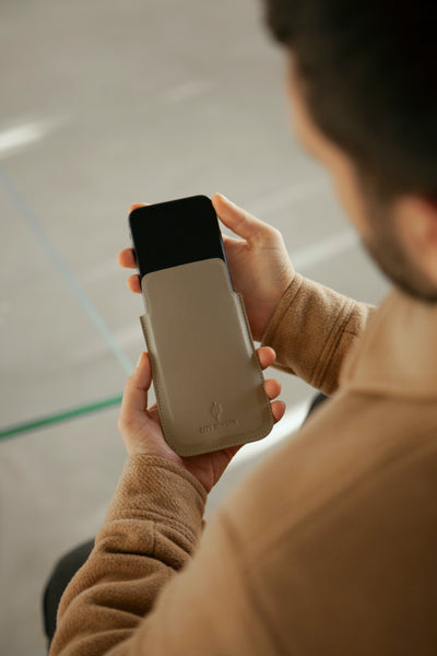 Ein Mann hält sein Smartphone mit der Bastei Handyhülle von City Border in der Hand, bequem zu bedienen. Handyhülle Universal.