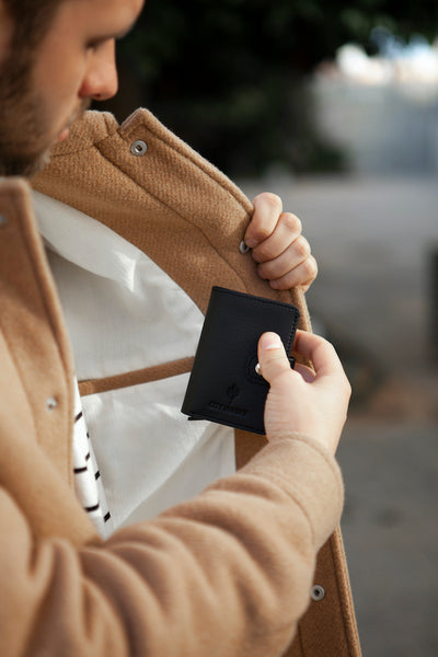 Der schwarze Cardholder mit Scheinfach Kaktusleder von City Border wird in einer Tasche verstaut, was die praktische Handhabung zeigt.