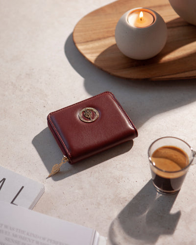 Stimmungsvolle Aufnahme des Oya Portemonnaies aus 
Desserto Kaktusleder in Rot, neben einer Tasse Kaffee, von City Border.
